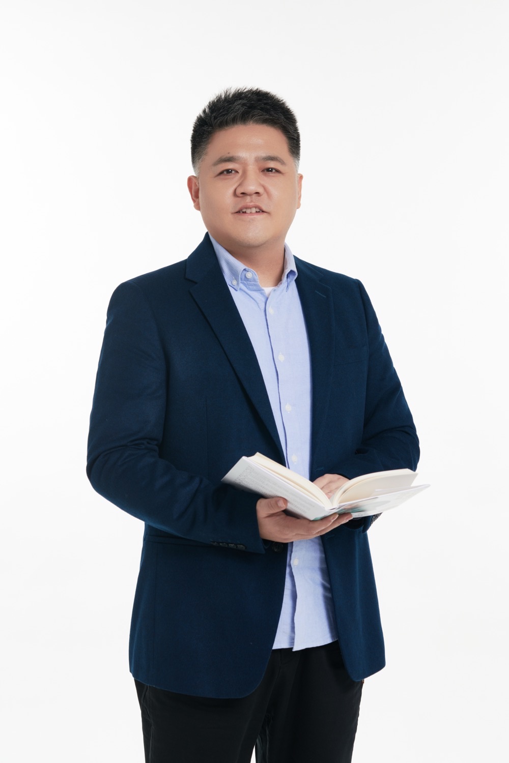 樊登肖像 —— 帆书(原樊登读书)创始人兼首席内容官,手持书籍